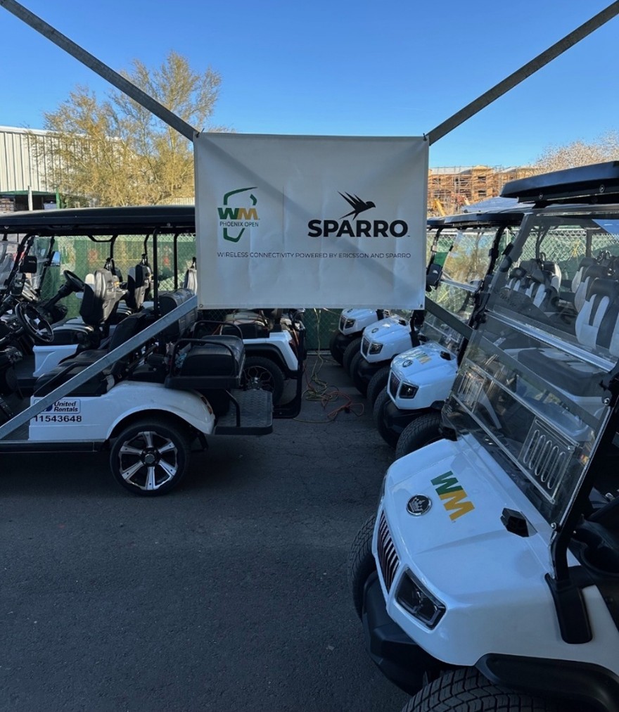 golf carts at WMPO behind a sign with the Sparro and WM logos
